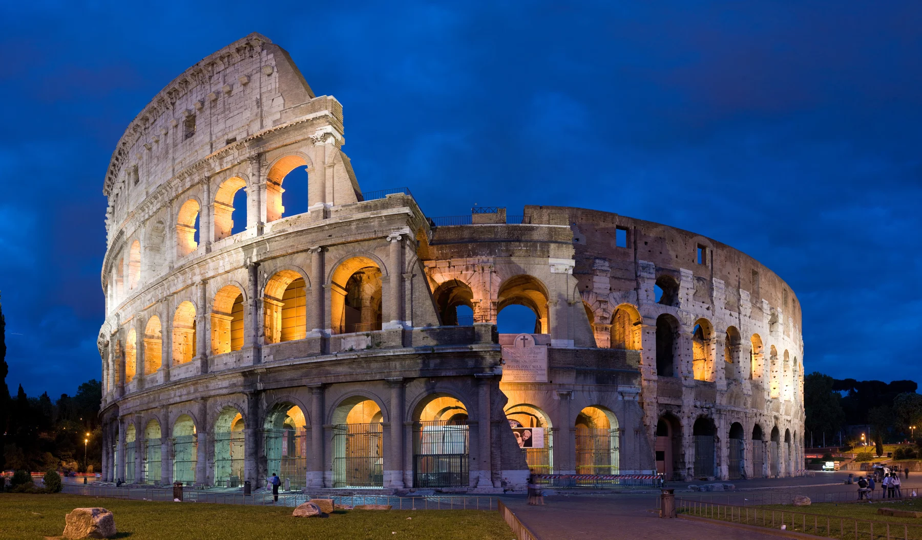 The exterior of the Colosseum illuminated at dusk