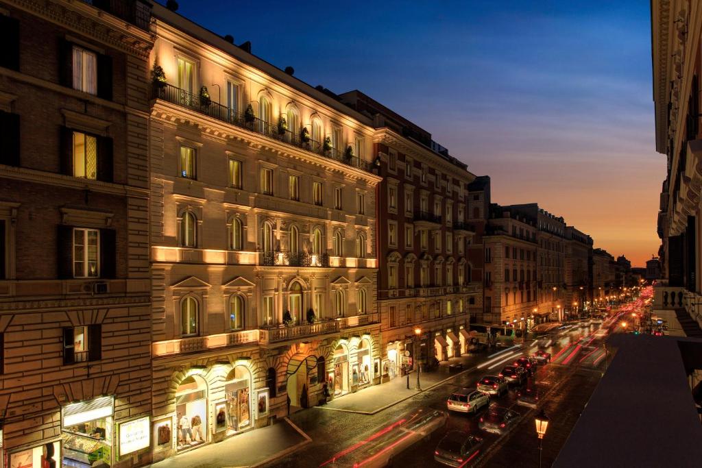 Die beleuchtete Fassade des Hotel Artemide an der Via Nazionale bei Nacht.